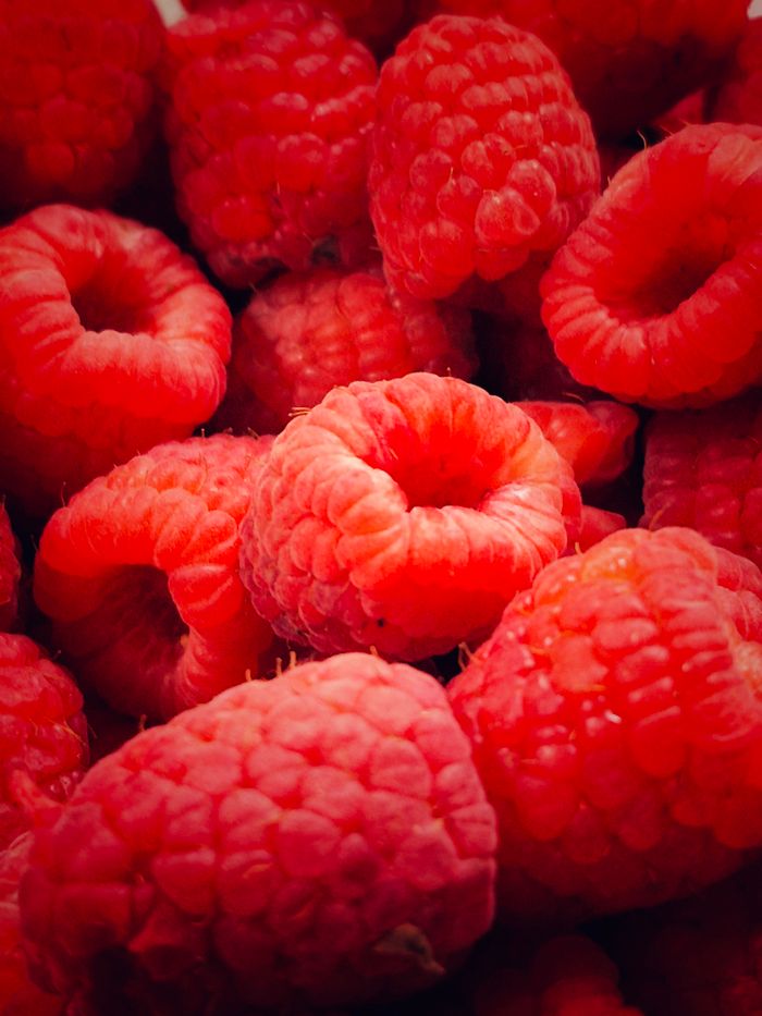 A vibrant close-up of fresh red raspberries showcasing their texture and color.