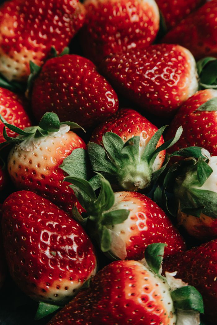 Vibrant ripe strawberries with leaves, showcasing freshness and natural sweetness.